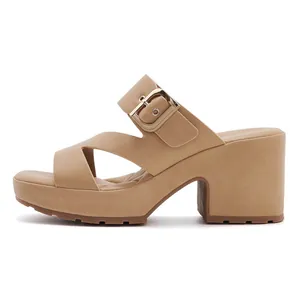 Detail view of khaki platform sandal featuring cross straps and large gold metal buckle