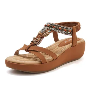 Λεπτομέρεια boho πέδιλο με πλατφόρμα, δερμάτινα λουράκια με χάντρες και μεταλλική πεταλούδα