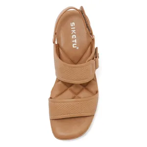 Detalle de sandalias marrones con plataforma, diseño de rombos y cierre ajustable