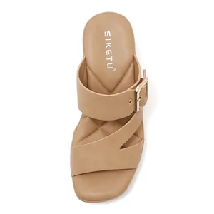 Detail of tan platform sandals with gold metal buckle and quilted diamond footbed