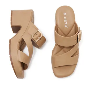 Close-up of khaki platform wedge sandals with gold buckles and quilted footbed