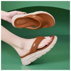 Close-up of brown platform flip flops featuring metal buckle and non-slip sole