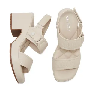 Detalle de sandalias de plataforma beige con correas de serpiente y cierre de velcro