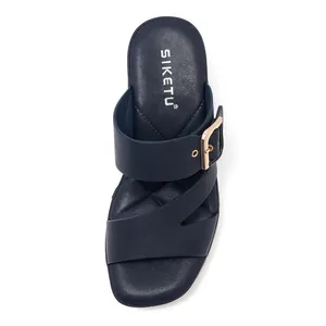 Detail view of navy blue platform sandals with gold buckle and quilted footbed pattern