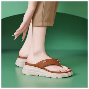 Detail of a brown platform thong sandal showing the silver logo and non-slip sole