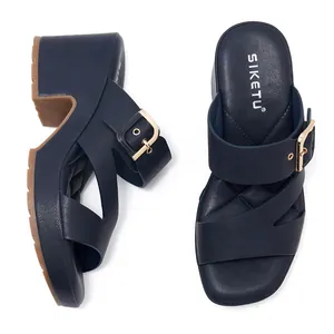 Detail of dark blue wedge sandals with diamond-quilted insole and golden buckle