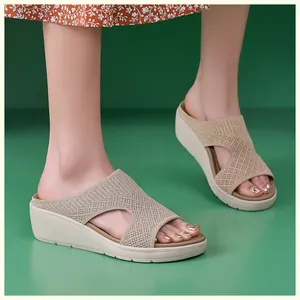 Vista dettagliata dei sandali beige con zeppa in maglia e paillettes scintillanti