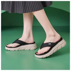 Detailed view of beige wedge flip flops with black straps and silver brand emblem on top