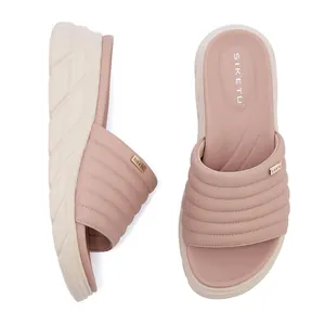 Dettaglio di sandali con zeppa rosa con cinturini trapuntati a onde e logo dorato