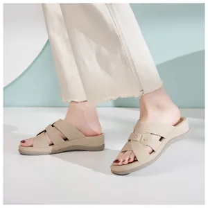 Detailansicht der beigefarbenen Keilsandalen mit überkreuzten Riemen und Nieten