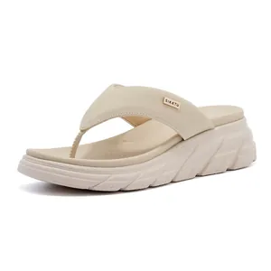 Detailed side view of off-white platform flip-flops with gold metal brand ornament