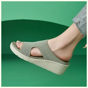 Vista laterale di sabot con zeppa verde erba da donna con tomaia in maglia traspirante