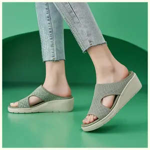 Vista dettagliata di sandali con zeppa verde menta con tomaia in maglia e decori in strass