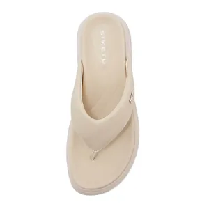 Detail of beige wedge flip flop with ergonomic footbed and high-quality leather texture