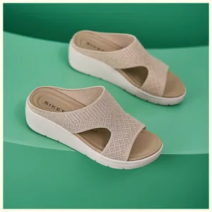 Dettaglio della tomaia in maglia traspirante e suola platform su sandali zeppa beige
