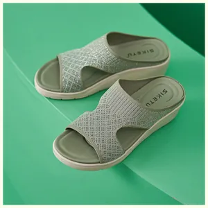 Dettaglio di sandalo platform in maglia verde con fili metallici e suola a zeppa