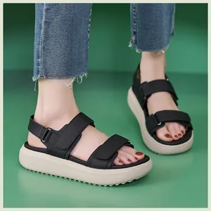 Detail van zwarte platform sandalen met klittenband en antislip rubberen sleehakzool
