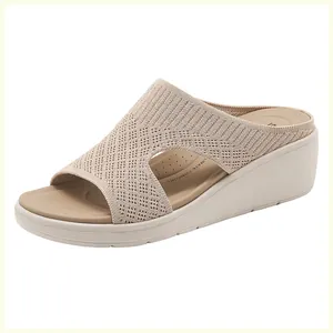 Dettaglio di sandali beige con zeppa che mostrano la maglia traspirante e il plantare