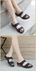 Detail of women's black wedge sandals featuring woven straps and brown wood texture soles