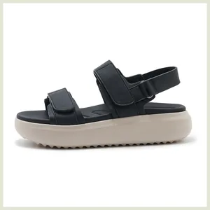 Detail van zwarte platform sandalen met klittenbandsluiting en slipvaste getande zool