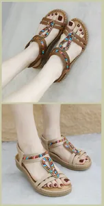 Detail of bohemian flat sandals with colorful beaded T-straps and elastic heel bands