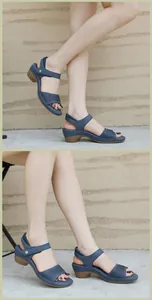 Détail de sandales compensées bleues avec motifs ajourés et boucles dorées élégantes