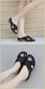 Detail view of black wedge sandals featuring rhinestone cross straps and wedge heel