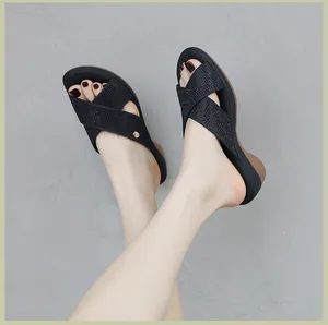 Detail of wedge sandals featuring black rhinestone cross straps and comfortable heels
