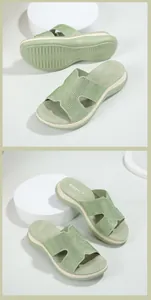 Close-up of light green wedge sandals featuring rhinestones on the H-strap and brand logo