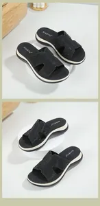 Close-up of black platform wedge sandals featuring rhinestone H-shaped cutout straps
