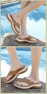 Gros plan de tongs compensées marron avec strass étincelants au bord de la piscine