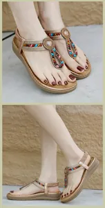 Detail of bohemian wedge sandals with colorful beads and golden braided straps