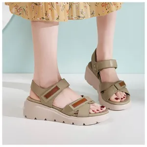 Dettaglio dei sandali con zeppa verde oliva con velcro e suola platform testurizzata