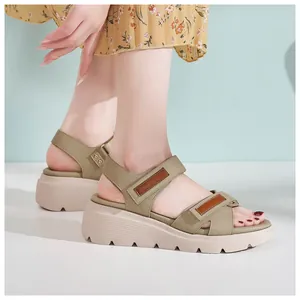 Dettaglio di sandali con zeppa, velcro e suola spessa antiscivolo indossati da modella
