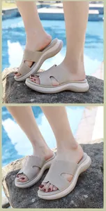 Close-up of rhinestone hollow straps on women's beige platform wedge slide sandals