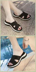 Detail of black H-shaped wedge flip-flops with rhinestone embellishments on the beach