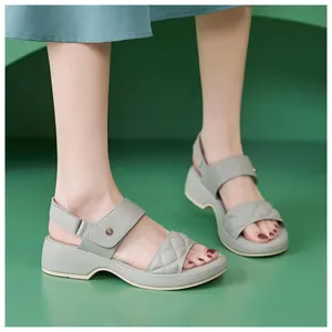 Detail of light green wedge sandal with quilted strap and adjustable velcro closure