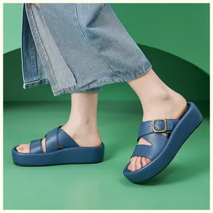 Détail de sandales compensées bleu marine avec brides croisées et boucles métalliques