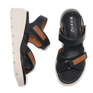 Dettaglio di sandali con zeppa in pelle, cinturini in velcro regolabili e suola antiscivolo