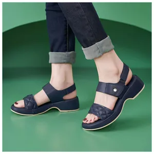Side view of navy blue wedge sandals with quilted straps and metallic buckle detail