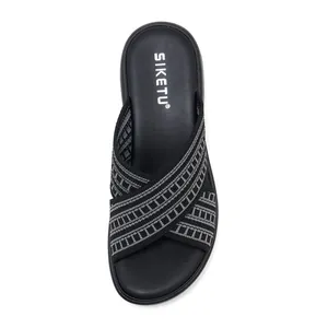 Detail of black woven cross straps with geometric texture on thick sole slide sandals