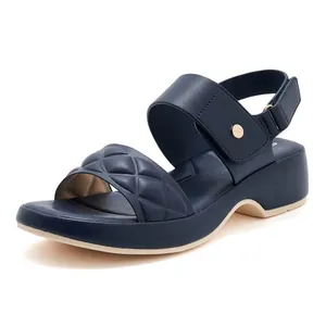 Detail view of navy wedge sandals featuring diamond-quilted faux leather and velcro strap