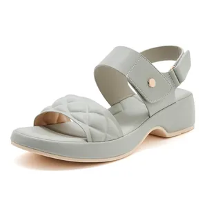 Detail of mint green wedge sandal with quilted strap and gold metal buckle logo