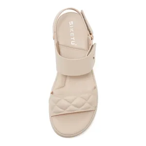 Close-up of beige summer sandals with quilted texture and adjustable heel strap