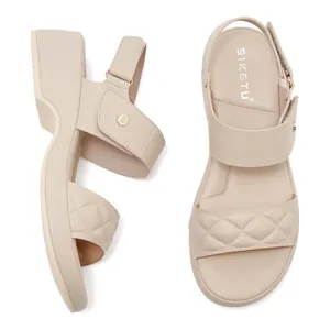 Detail view of beige wedge sandals featuring quilted straps and thick comfortable soles