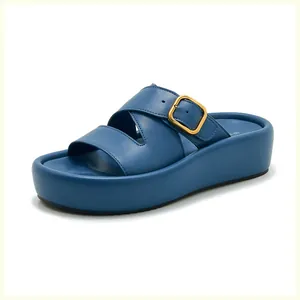 Détail d'une sandale plateforme bleu foncé avec brides croisées et boucle dorée