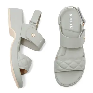 Detail view of quilted platform sandals with metallic buckle and wedge sole textures