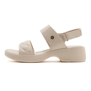Close-up of beige platform sandal featuring quilted texture and metallic buckle detail
