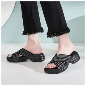 Detail view of black platform slide with plaid cross straps and thick wavy sole