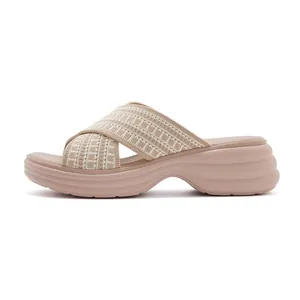 Close-up of beige platform slide sandal with cross knit straps and wavy wedge sole